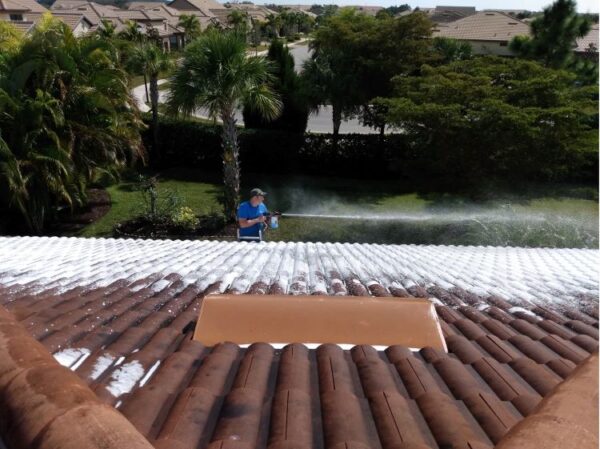 man washing tile roof